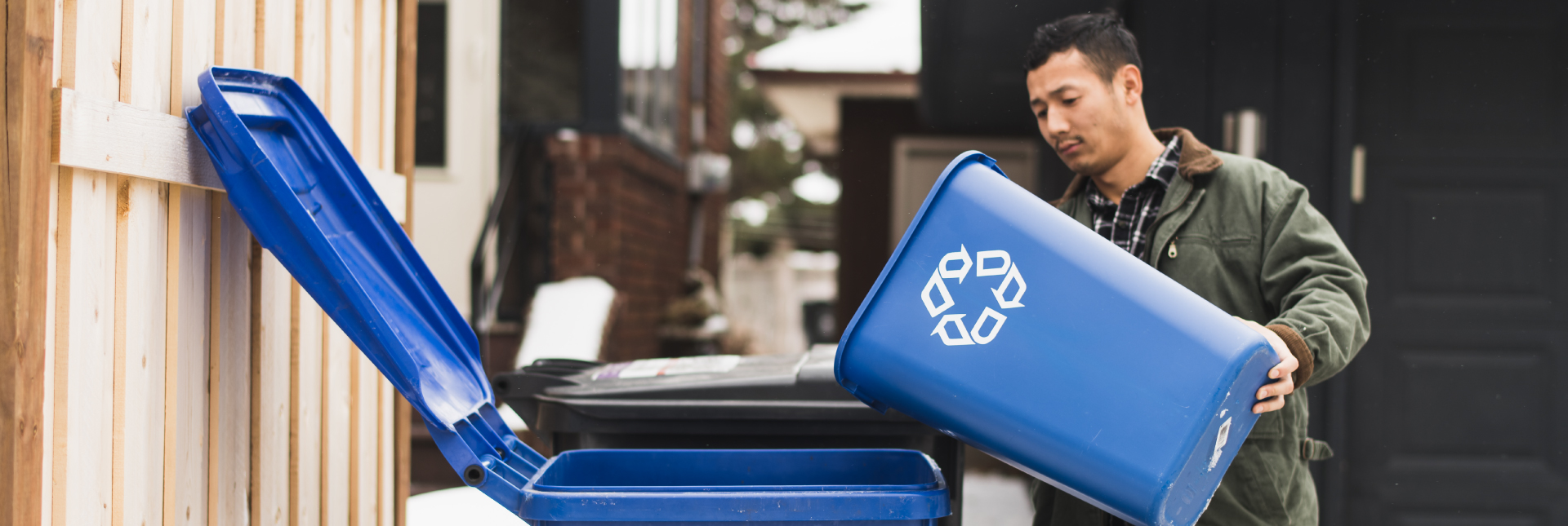 Man emptying recycling into recycling bin