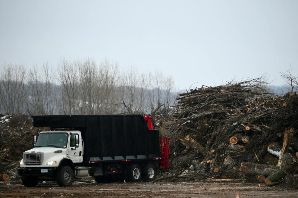 Truck dumping wood waste into a pile
