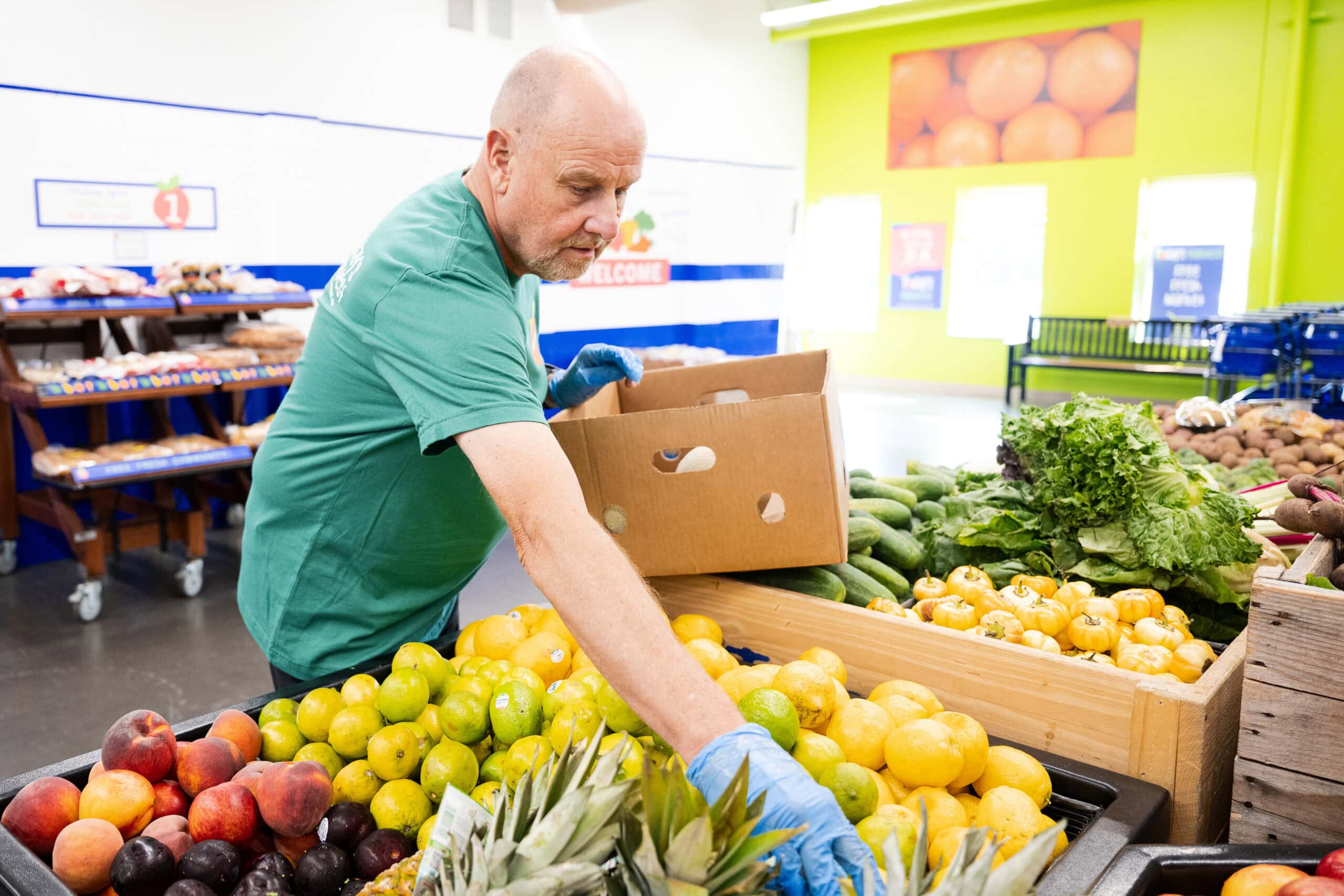 Volunteer putting produce on floor at food shelf
