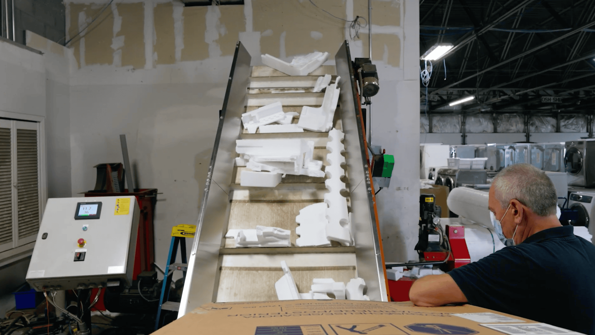 Photo of man from behind working near a conveyer belt